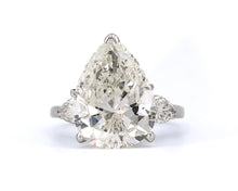 Load image into Gallery viewer, Front view of a platinum three-stone engagement ring featuring a 7.63CT pear-shaped diamond centered between two smaller pear-shaped diamonds.
