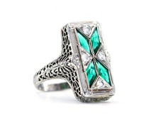 Load image into Gallery viewer, A vintage 1920's emerald and diamond filigree ring with a white gold band, featuring four bezel set lozenge cut synthetic emeralds and four 3 prong set old european cut diamonds.