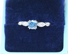 Load image into Gallery viewer, Vintage platinum ring set in the center with a color enhanced fancy blue round diamond, with white diamond side stones.