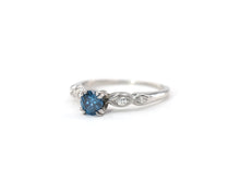 Load image into Gallery viewer, Vintage platinum ring set in the center with a color enhanced fancy blue round diamond, with white diamond side stones.