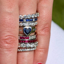 Load image into Gallery viewer, Stack of colorful rings on a finger with a blurred background