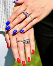 Load image into Gallery viewer, Close-up of hands with blue and red nail polish wearing multiple rings.