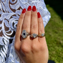 Load image into Gallery viewer, Hand wearing multiple antique rings against a white lace fabric and blurred background.