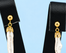 Load image into Gallery viewer, Close-up view of the 14K yellow gold pearl cup and top section of the long white pearl dangler earring.
