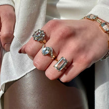Load image into Gallery viewer, Close-up of a hand wearing multiple rings with aquamarine gemstones on a neutral background
