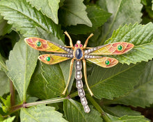 Load image into Gallery viewer, Vintage 18k yellow gold and sterling silver dragonfly brooch set with blue sapphire, diamonds, emeralds, and rubies pictured on a leaf.
