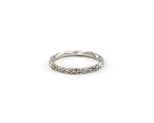 14K white gold wedding band featuring beautifully carved flowers in an eternity style.