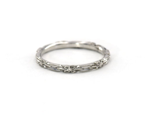 Vintage 14K white gold wedding band featuring beautifully carved flowers in an eternity style.