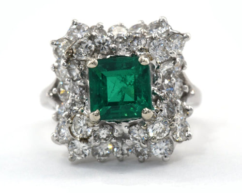 Estate 18K white gold ring set with emerald and diamonds.