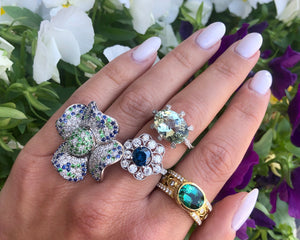 18K white gold fancy blue and white diamond flower ring worn with other beautiful, colorful spring rings.